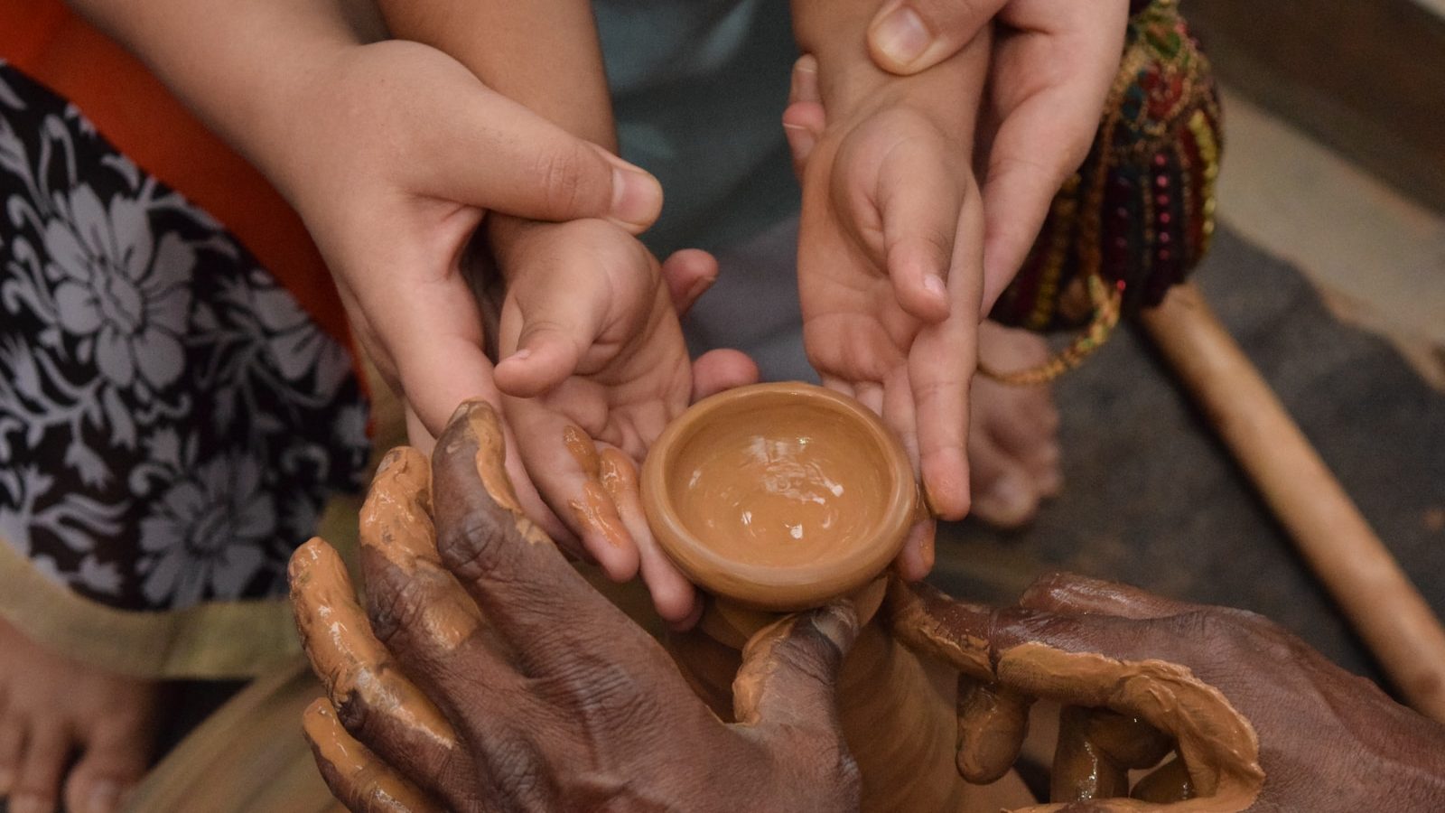 woman holding child's hand towards jar