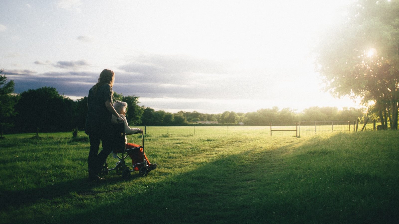 woman standing next to woman riding wheelchair