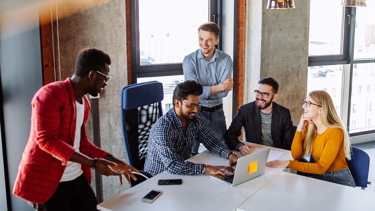 Coworkers sit around table brainstorming