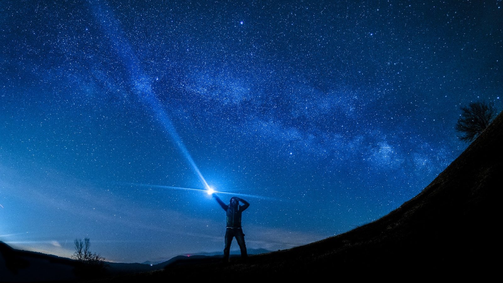 silhouette of man holding flashlight