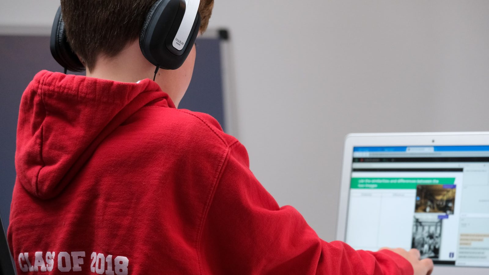 boy in red hoodie wearing black headphones