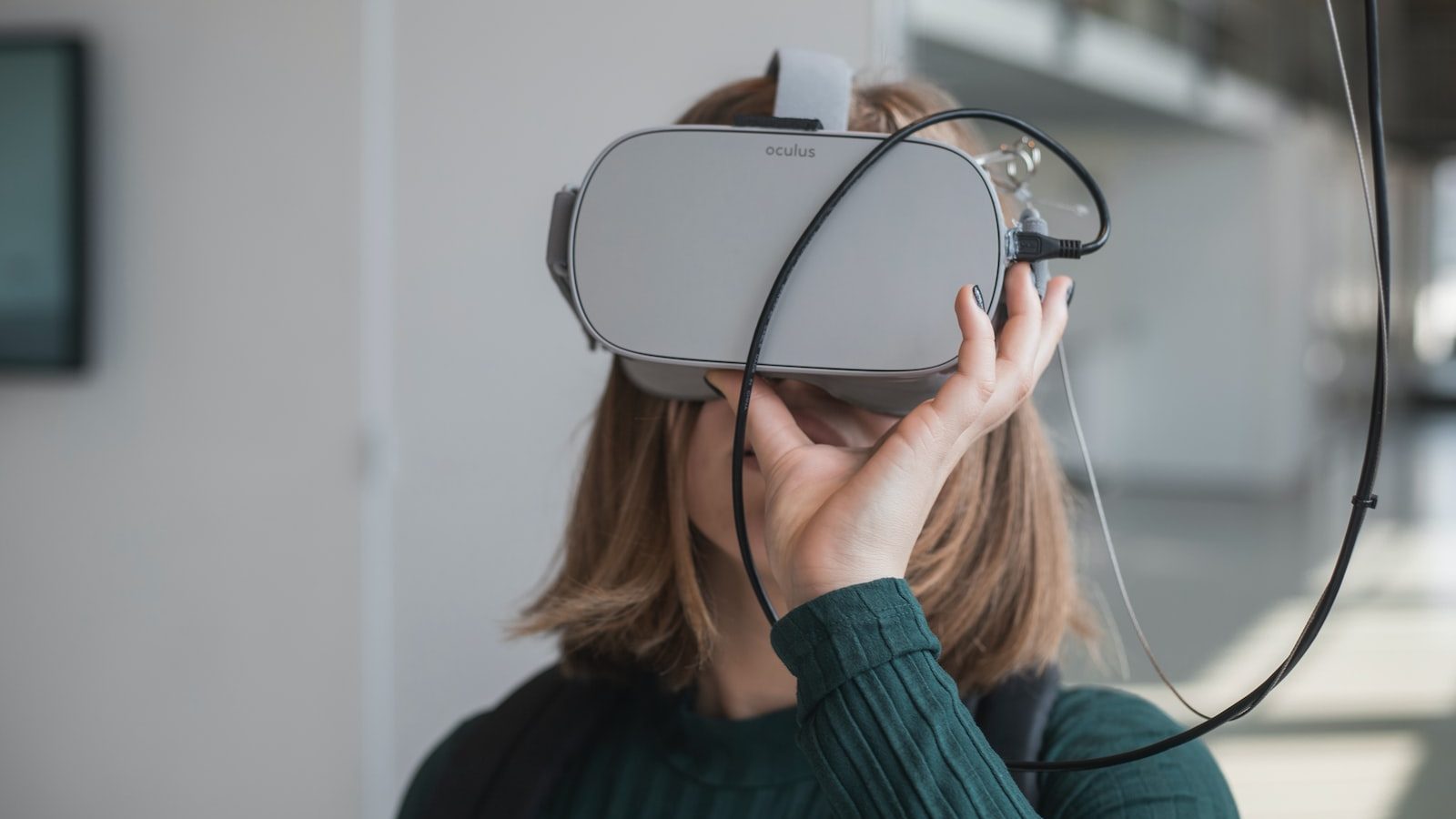 woman in black sweater holding white and black vr goggles