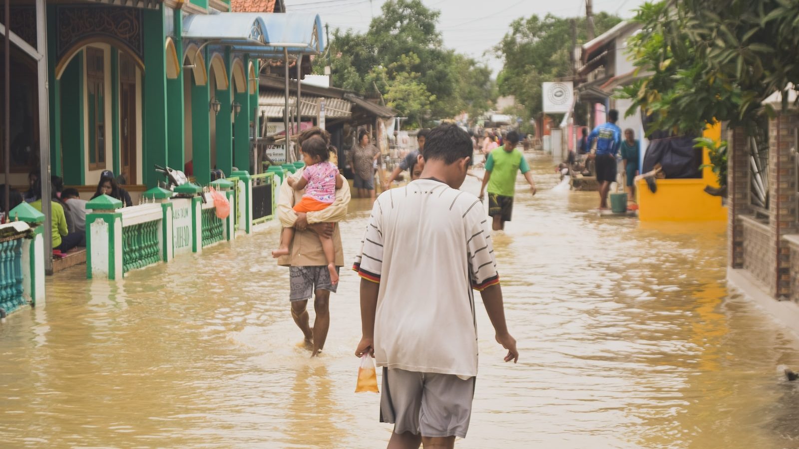 people walk down flooded streets, cities will need to adapt to climate change