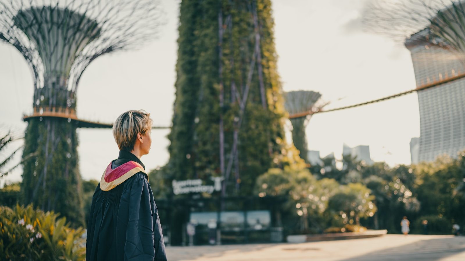 woman in black coat standing on road during daytime