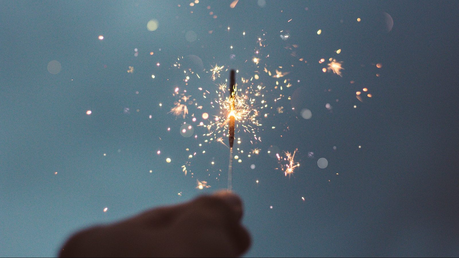 person holding lighted sparklers