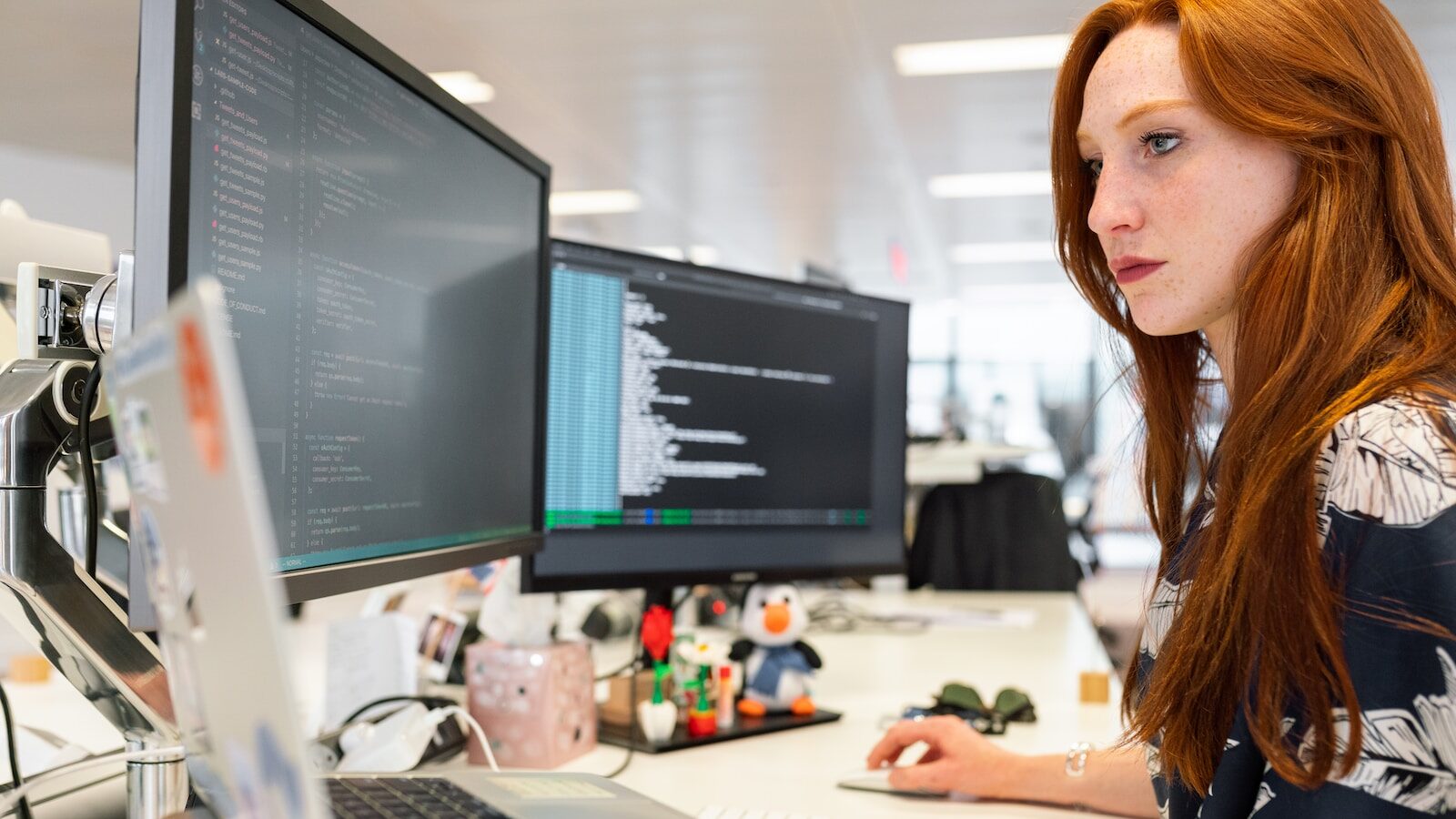 woman in green shirt sitting in front of computer