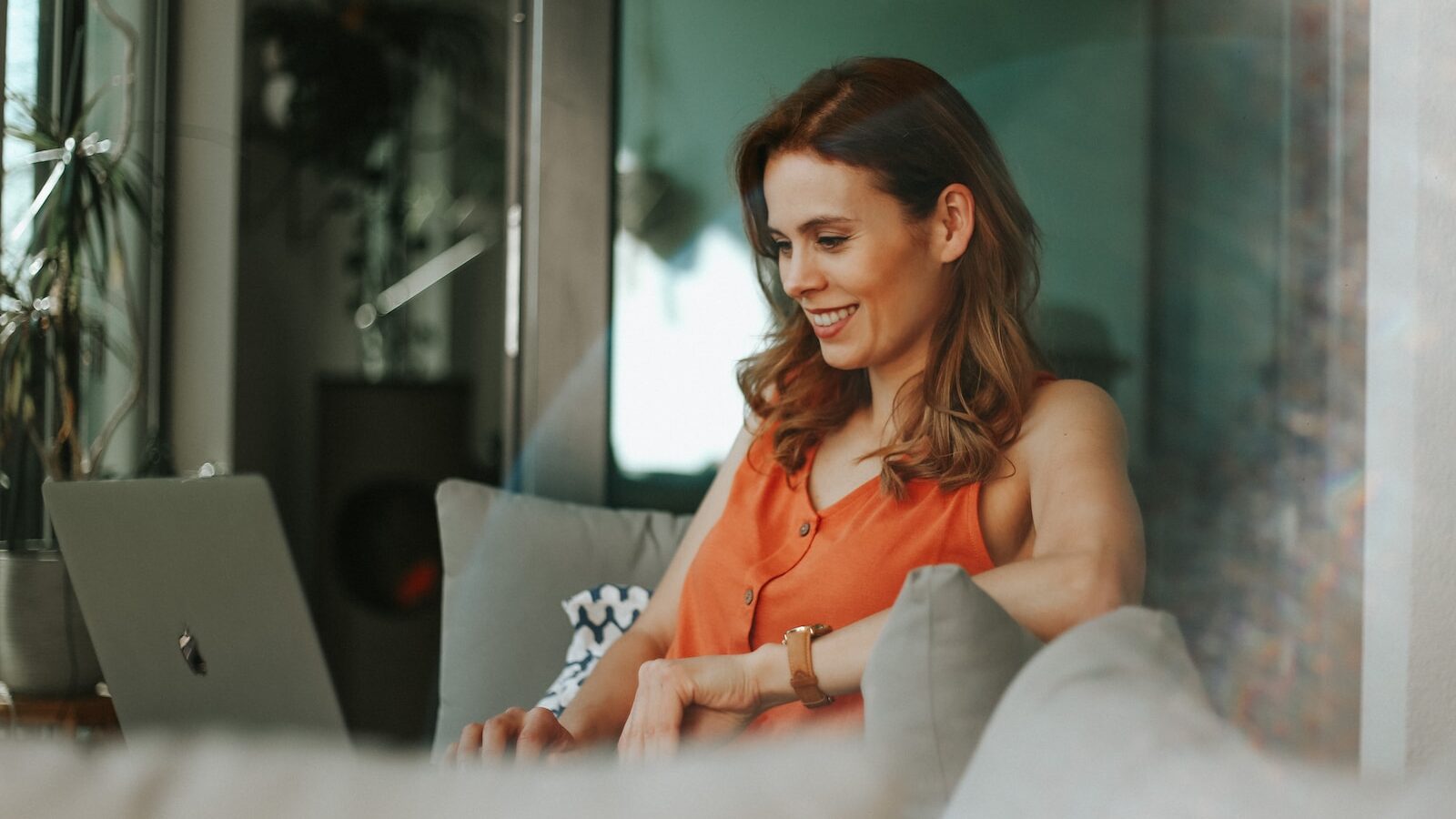 woman in orange sleeveless top sitting on couch