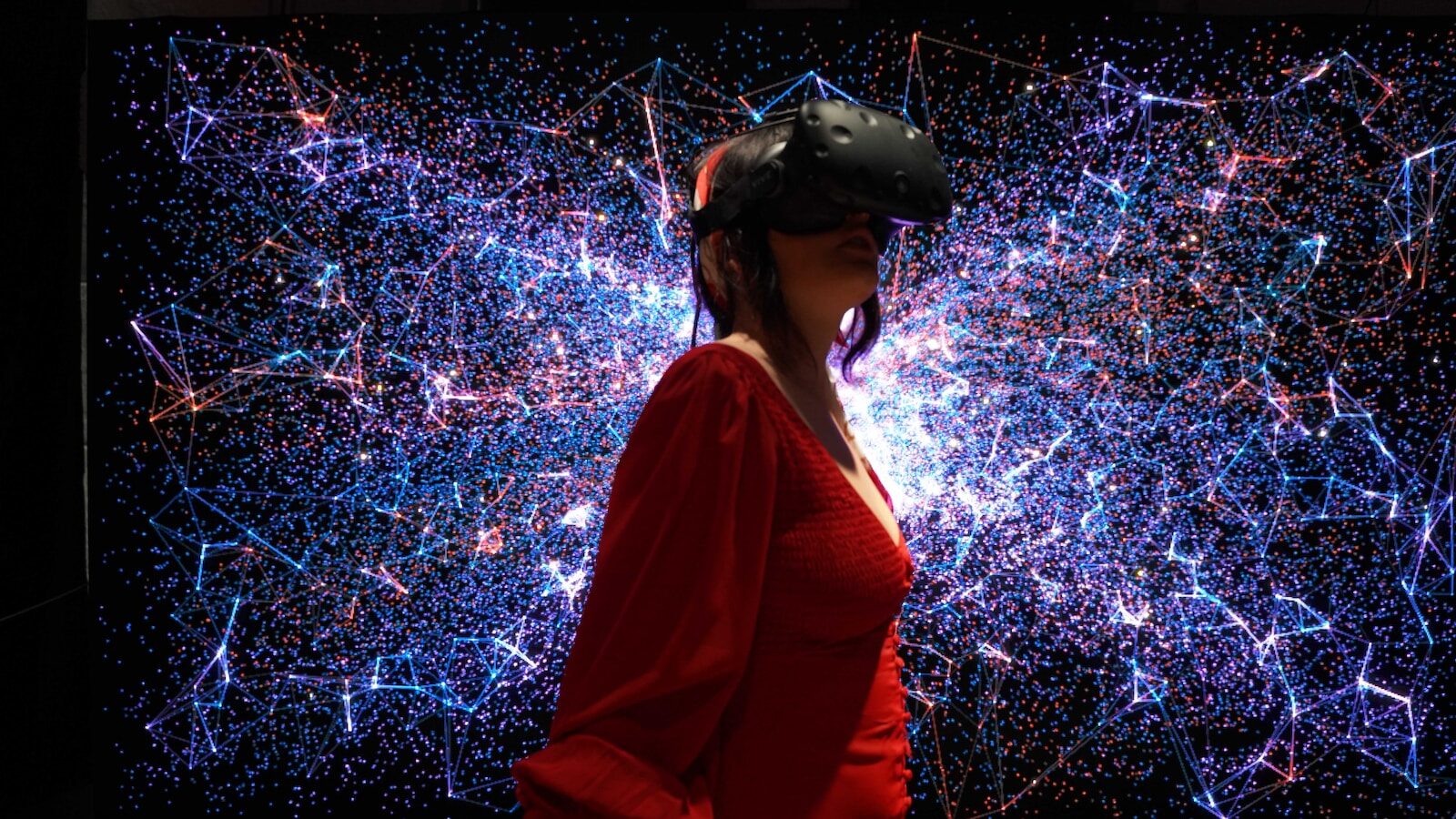 a woman in a red dress wearing a virtual reality headset