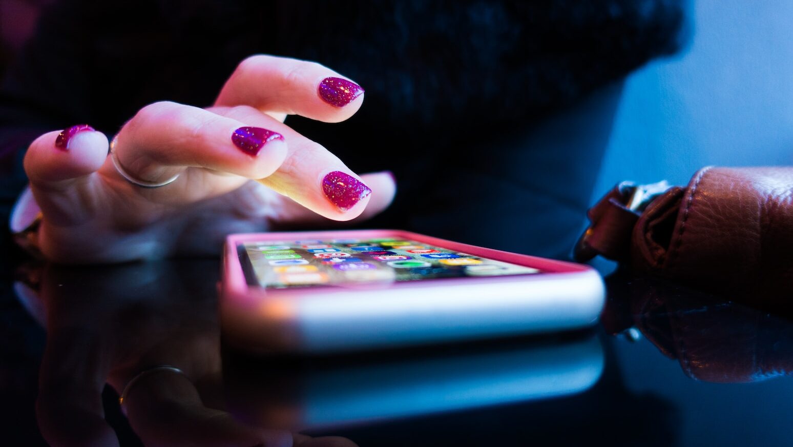 person using black smartphone with gray and pink case