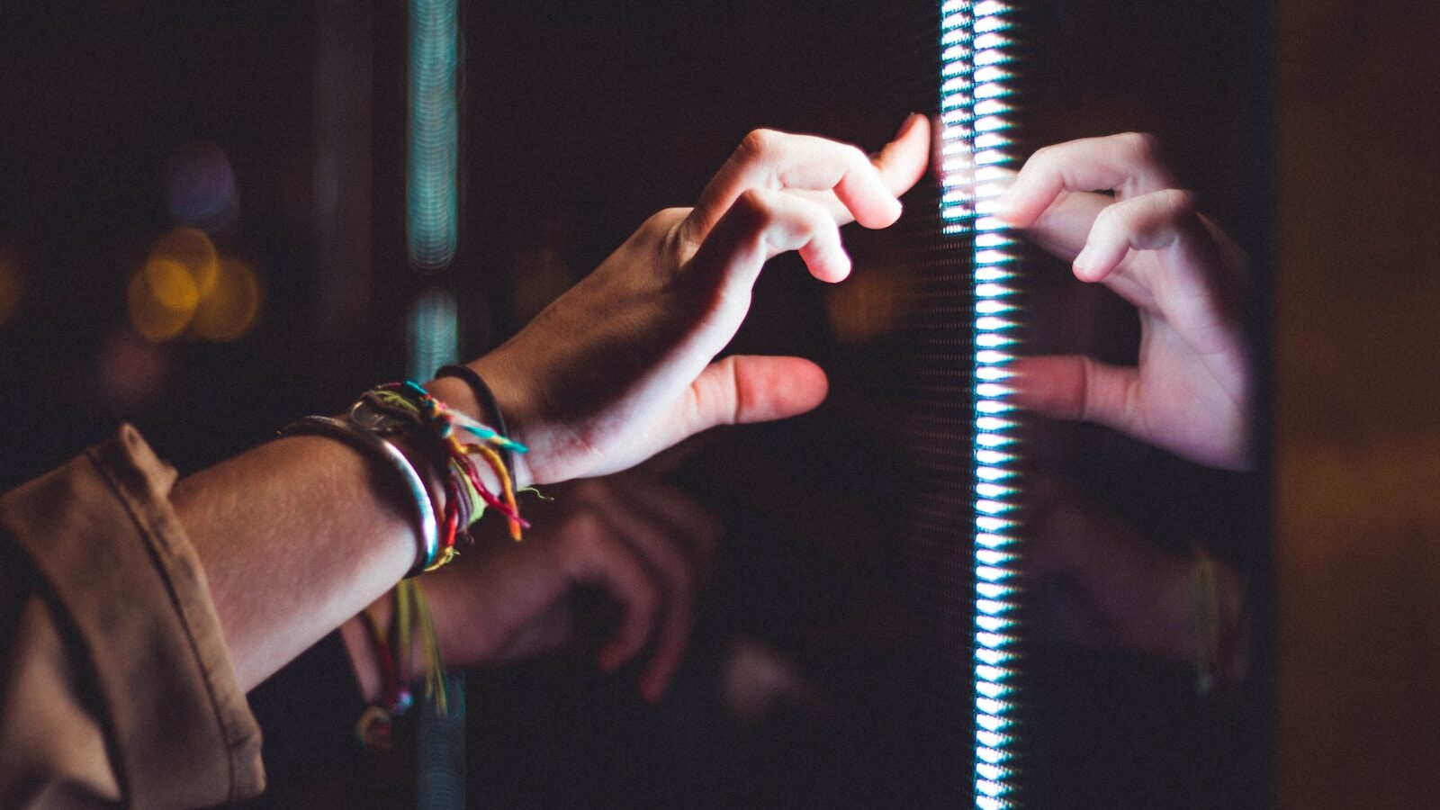 person wearing silver bracelet holding a light