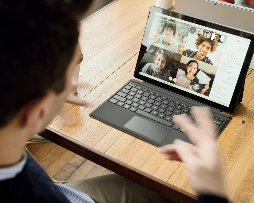 A group uses technology like laptops to make a video call