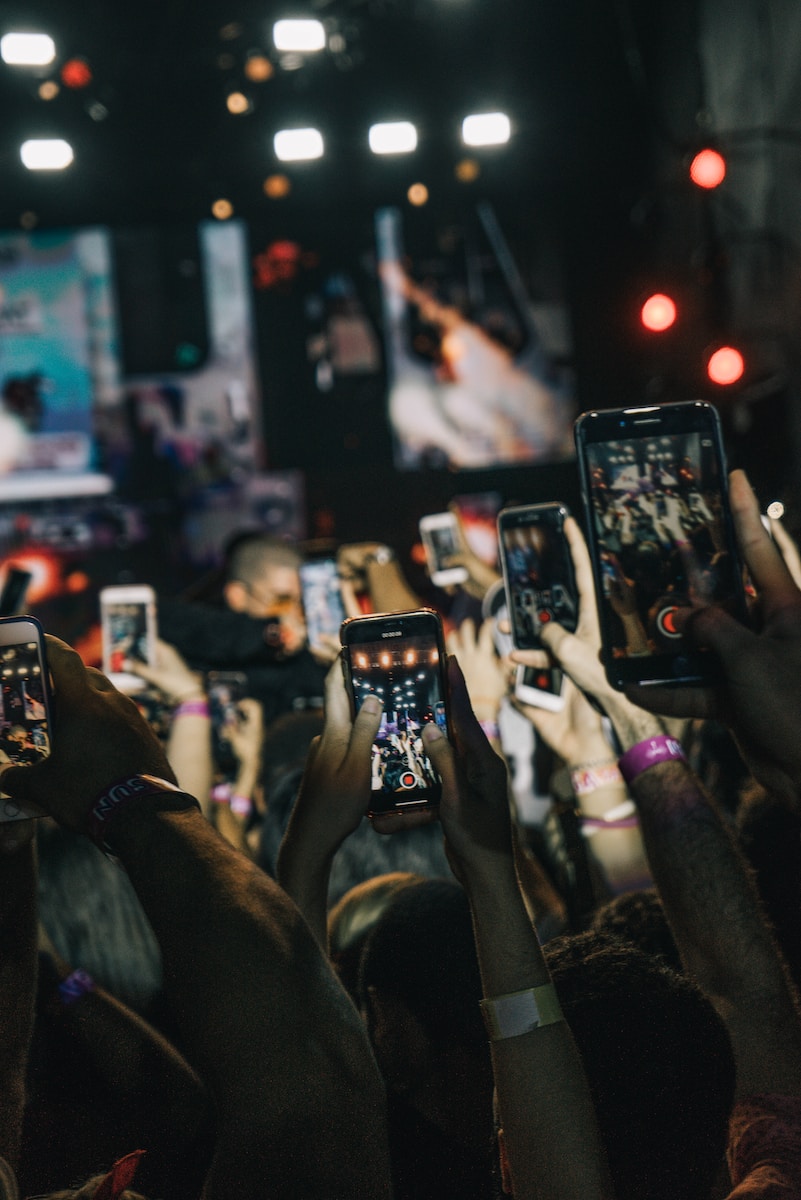 An example of social impacts of technology, close-up of crowd using cell-phones to capture video at a concert