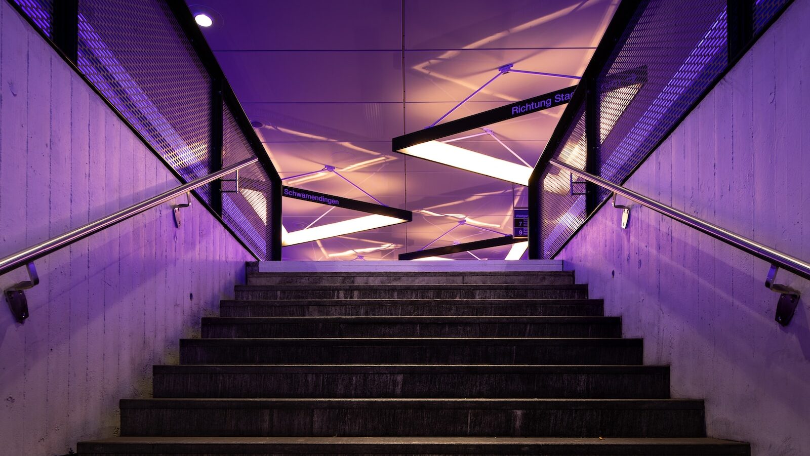 Decorative: AI takes personalized coach training to the next level. Image description: dark stairs with neon pink and purple lights