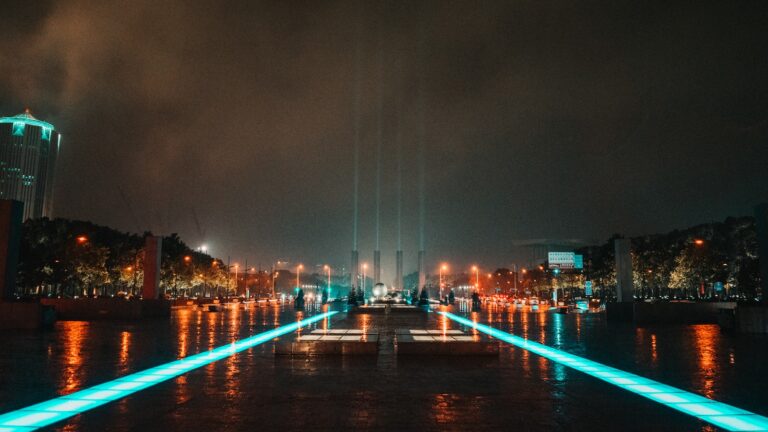 Decorative Image: coaches are key to strengthening human skills in the transition to Industry 5.0. Image Description: a city at night with lights reflecting in the water