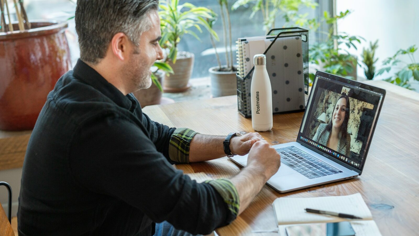 man in black sweater using laptop to make a video call
